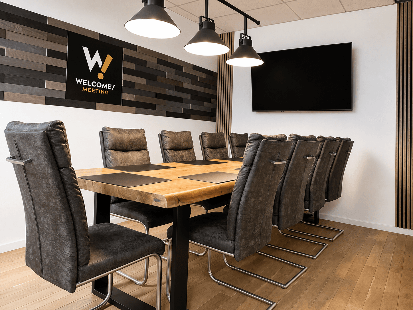 Premium meeting room with a large wooden table, black chairs and a screen